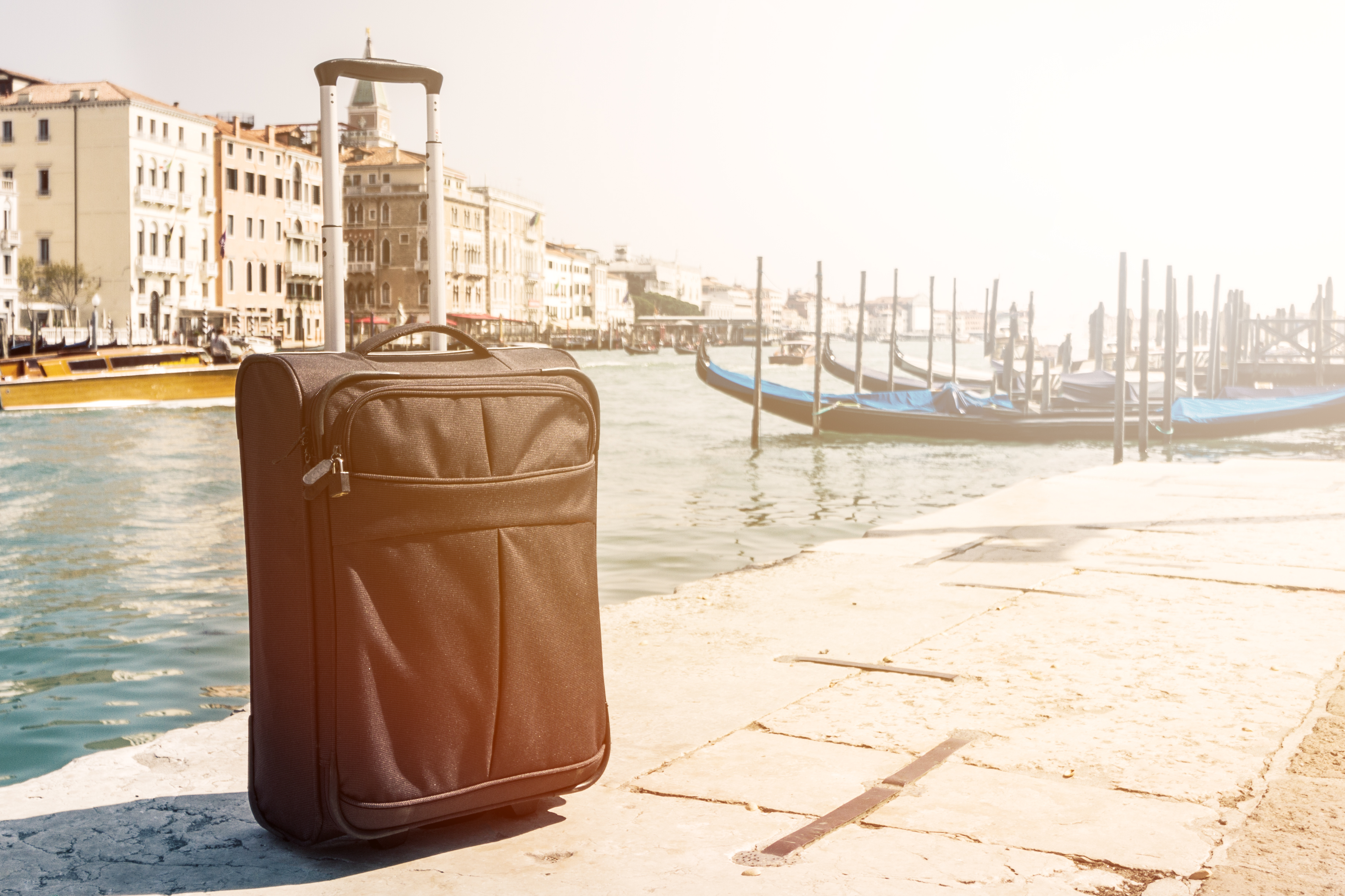Small Suitcase on Travel Urban Background, Venice, Italy. Horizontal. Toning. Travel Vacation Concept.