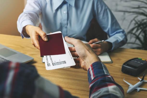 travel agent giving flight tickets and documents to customer in agency office
